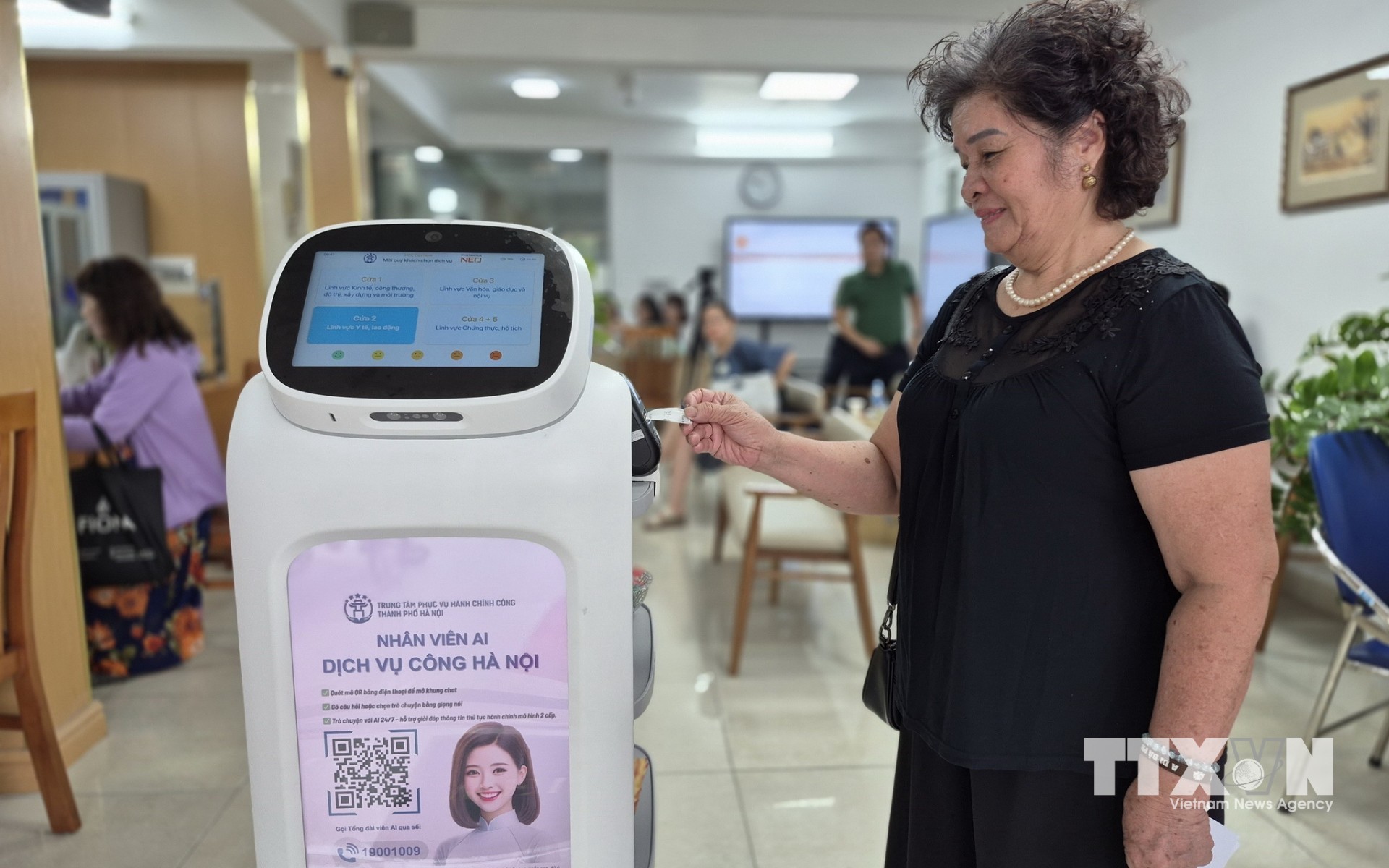 Người dân trải nghiệm robot AI áp dụng công nghệ trí tuệ nhân tạo hỗ trợ thực hiện các thủ tục hành chính tại phường Cửa Nam, Hà Nội. (Ảnh: Nguyễn Thắng/TTXVN)